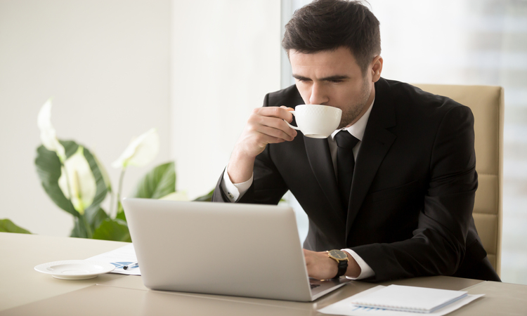 Homem tomando afé enquanto bebe café em uma xícara.