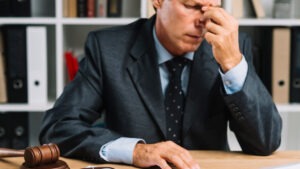 Advogado com a mão no rosto, demonstrando frustração após erro na contratação de um correspondente jurídico.